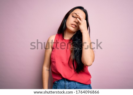 Young brunette woman wearing casual summer shirt over pink isolated background tired rubbing nose and eyes feeling fatigue and headache. Stress and frustration concept.