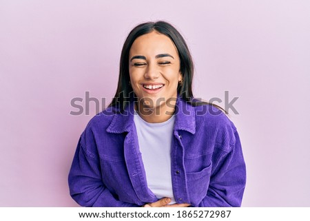 Young brunette woman wearing casual clothes smiling and laughing hard out loud because funny crazy joke with hands on body. 