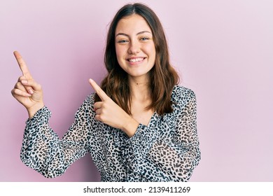 Young Brunette Woman Wearing Elegant Animal Print Shirt Smiling And Looking At The Camera Pointing With Two Hands And Fingers To The Side. 