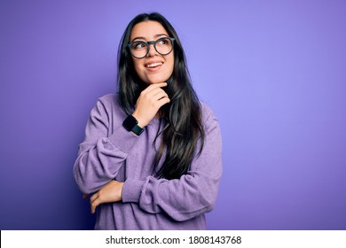 Young brunette woman wearing glasses over purple isolated background with hand on chin thinking about question, pensive expression. Smiling with thoughtful face. Doubt concept. - Shutterstock ID 1808143768