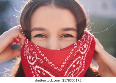 Young Brunette Woman Wearing Red Bandana Covering Half Of Face, Looking At Camera, Activist Protest Concept.