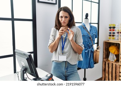 Young Brunette Woman Working As Manager At Retail Boutique Disgusted Expression, Displeased And Fearful Doing Disgust Face Because Aversion Reaction. With Hands Raised 