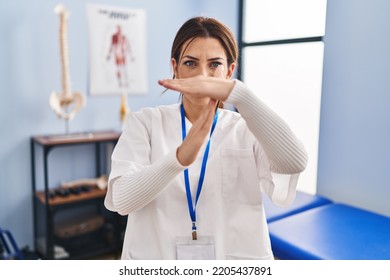 Young brunette woman working at pain recovery clinic doing time out gesture with hands, frustrated and serious face  - Shutterstock ID 2205437891