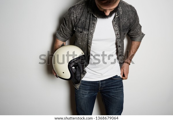 Young brutal bearded male model poses in black\
shirt jeans and blank white t-shirt premium summer cotton, on white\
background