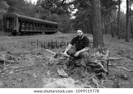 Similar – Foto Bild bärtiger Holzfäller mit einer Axt, die neben einem rostigen Zug sitzt.