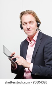 Young Buisness Man In Office With Headset And Tablet Wearing Blue Suit And Pink Shirt. Isolated On White Background.