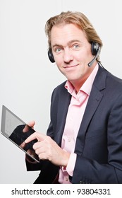 Young Buisness Man In Office With Headset And Tablet Wearing Blue Suit And Pink Shirt. Isolated On White Background.