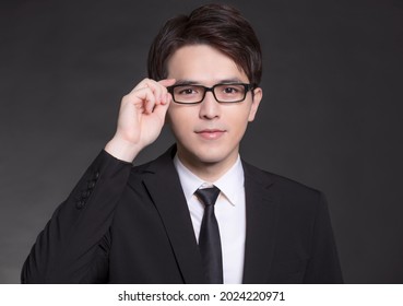 Young Buisnessman In Black Suit And Wearing Eyeglasses