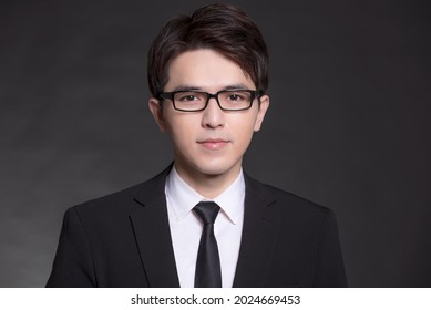 Young Buisnessman In Black Suit And Wearing Eyeglasses