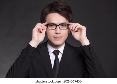 Young Buisnessman In Black Suit And Wearing Eyeglasses