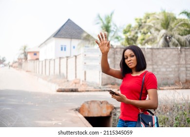 Young Business African Woman With Smart Phone Hailing Taxi