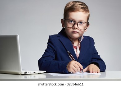 Young business boy. funny child in glasses writing pen. little boss in office