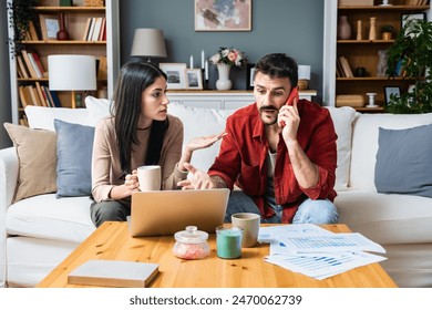 Young business couple freelance workers, small startup company owners, colleagues working at home, having bad slow internet connection, calling internet provider to complain about low connectivity. - Powered by Shutterstock