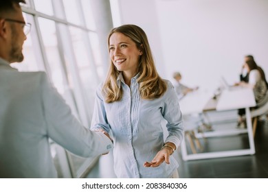 Young business couple handshaking in the office in front of their team - Powered by Shutterstock