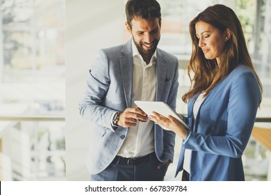 Young Business Couple Working On Tablet In Modern Office