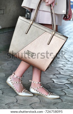 Young business elegant woman wearing sandals with belts and holding bag 