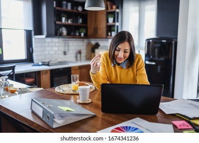 Young business entrepreneur woman working at home while having breakfast