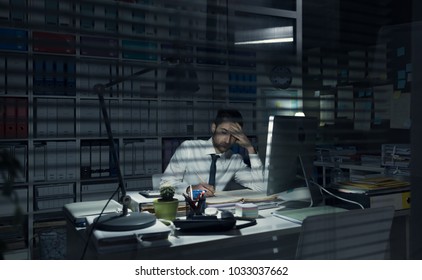 Young business executive working in the office late at night, deadlines and overtime work concept
