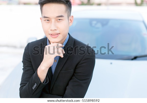 Young business man\
in black suite with car