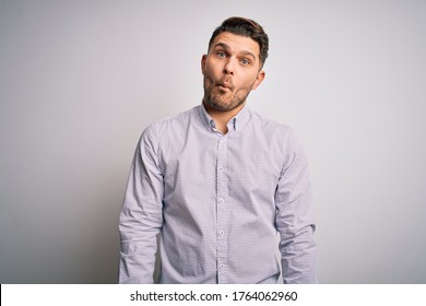 Young business man with blue eyes standing over isolated background making fish face with lips, crazy and comical gesture. Funny expression. - Shutterstock ID 1764062960