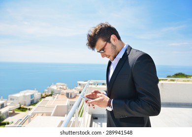 Young Business Man Calling By Cell Phone On White Beach