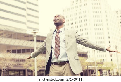 Young business man celebrates freedom success arms raised looking up to sky. Positive human emotions face expression feelings 