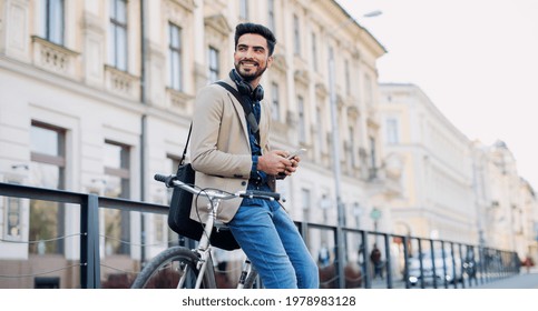 Young business man commuter with bicycle going to work outdoors in city, using smartphone. - Powered by Shutterstock