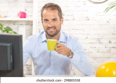 A Young Business Man Drinking A Cup Of Coffee On His Office