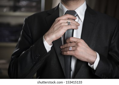 Young Business Man Fixing his Tie