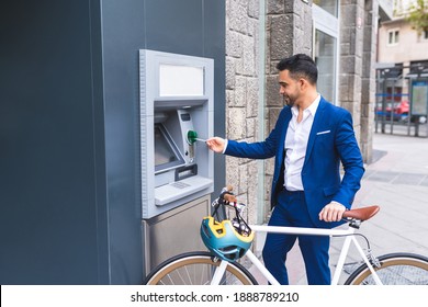 Young Business Man Getting Cash from ATM. Latino Man Using Credit Card at ATM. Lifestyle Concept.