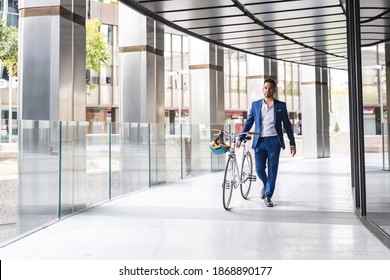 Young Business Man Going To Work By Bike. Latino Businessman Riding Bike To Work. Lifestyle Concept.