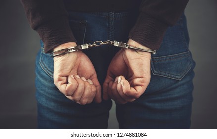 young business man hand handcuffs on dark background - Shutterstock ID 1274881084