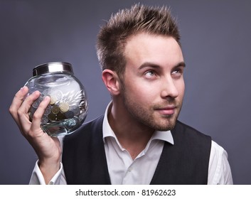 Young Business Man Holding Jar With Coins  - Retirement Fund And Savings Concept