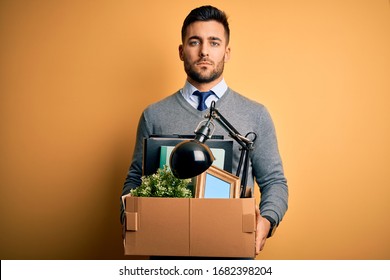 Young Business Man Holding Office Box Being Fired From Job Over Yellow Background With A Confident Expression On Smart Face Thinking Serious