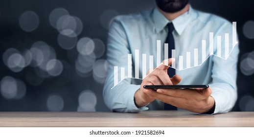 Young business man holding tablet with graph