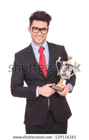 young business man holding a trophy and smiling to the camera, on white