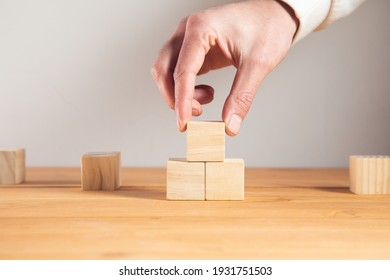 young business man holding wooden cubes.