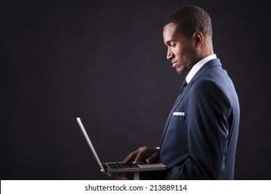 Young Business Man With A Laptop Over Dark Background