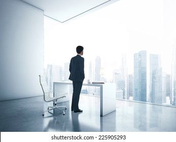 Young Business Man Looking Megalopolis Through Window