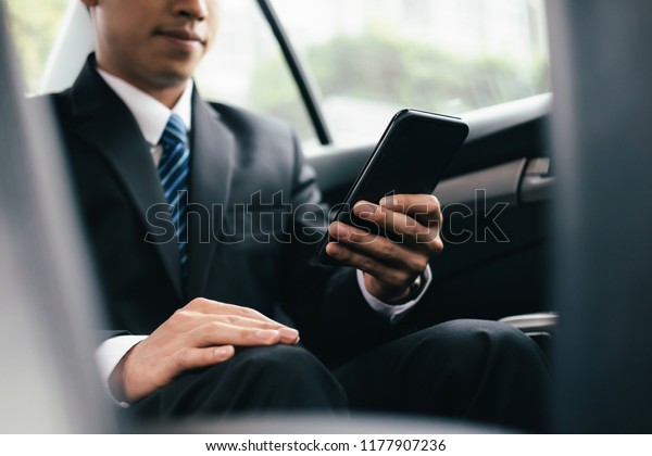 Young\
business man with phone in car. Mobile\
office.
