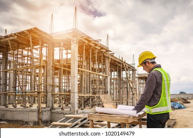young business man professional engineer worker at the house building construction site with blueprint