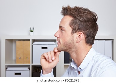 Young Business Man In Profile View With Hand On Chin In Office