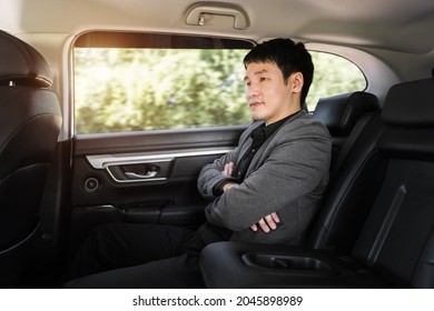 Young Business Man Sitting At The Back Seat Of Car