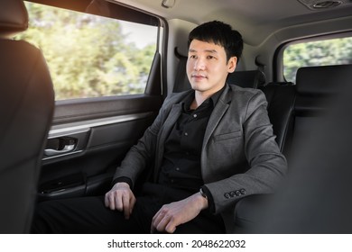 Young Business Man Sitting At The Back Seat Of Car