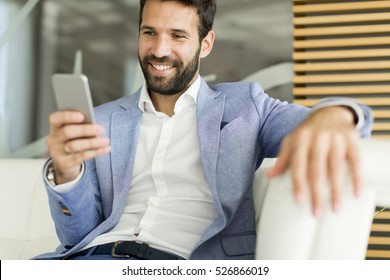 Young Business Man Sitting And Using Mobile Phone