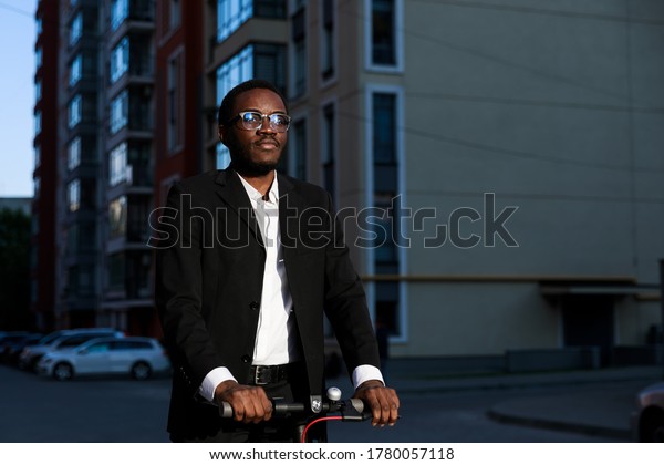 Young business man in suit riding an electric\
scooter at a business\
meeting.