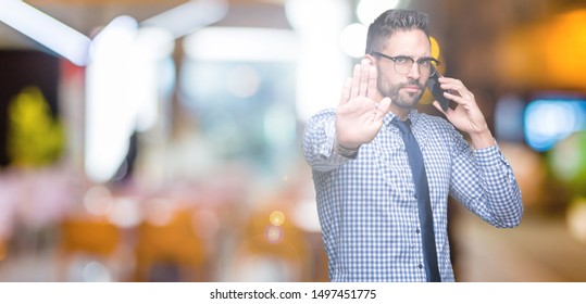 Young Business Man Talking On The Phone Over Isolated Background With Open Hand Doing Stop Sign With Serious And Confident Expression, Defense Gesture