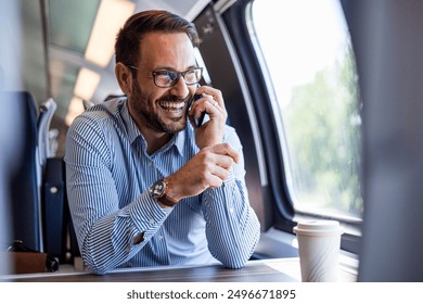 Young business man traveling to work by train, working while traveling, talking on phone. Young business man traveling to work by train.  - Powered by Shutterstock