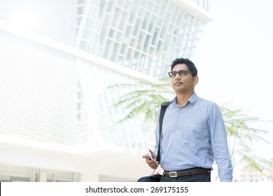 Young Business Man Walking By A Modern Office Building.