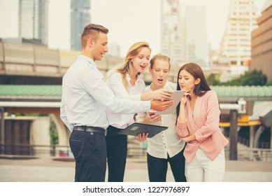 Young Business Man And Women Teamwork Talking While Standing Outdoor On City Background,looking At Ipad With Exciting Emotion As  A  Good News On Tablet,goal,business Success Concept,selective Focus.